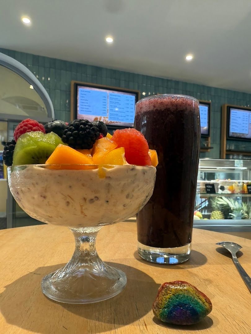 Frische Fruit Bowl mit Beeren, Kiwi und Mango neben einem dunklen Smoothie